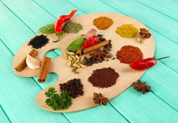 Painting palette with various spices and herbs, on color wooden background — Stock Photo, Image