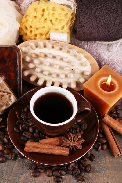 Cup with coffee drink, soap with coffee beans and spices, sponge and massage brush on wooden background. Coffee spa concept — Stock Photo, Image