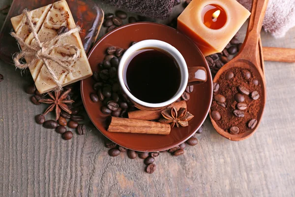 Cup met koffie drinken, zeep met koffiebonen en specerijen op houten achtergrond. Koffie spa concept — Stockfoto