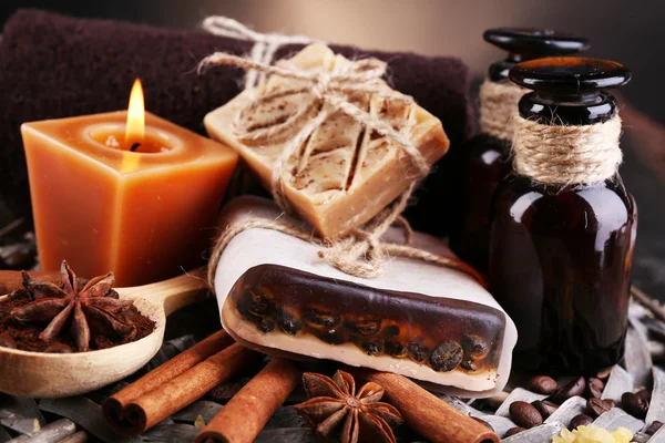 Органическое мыло с кофейными зёрнами, морская соль на плетеном коврике, на деревянном столе, на тёмном фоне, концепция кофейного спа — стоковое фото