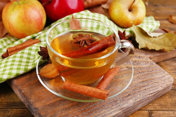 Composition of  apple cider with cinnamon sticks, fresh apples and autumn leaves on wooden background — Stock Photo, Image