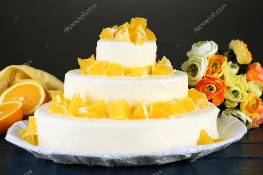 Beautiful wedding cake with oranges and chocolate on dark background