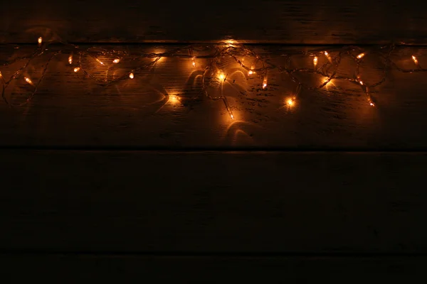 Luzes de Natal no fundo de madeira — Fotografia de Stock