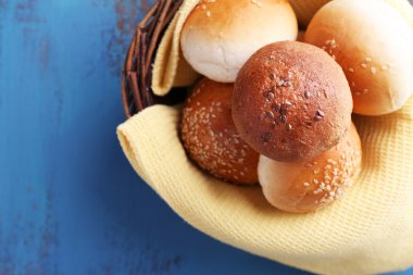 renkli ahşap zemin üzerinde hasır sepet içinde susam ile lezzetli çörekler