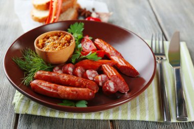 Lezzetli ince sosis tabakta ahşap arka plan üzerinde ürün yelpazesine