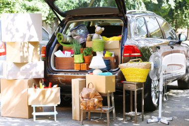 Moving boxes and suitcases in trunk of car, outdoors clipart