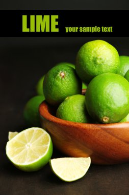 koyu arka plan üzerinde ahşap kase taze sulu limes