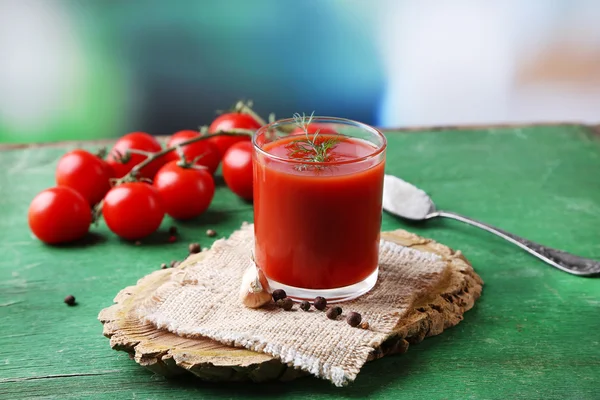 Sumo de tomate caseiro em vidro, especiarias e tomates frescos em fundo de madeira — Fotografia de Stock