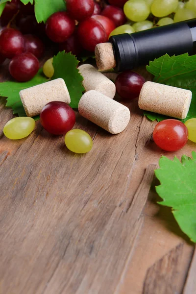 Wine bottle corks with grapes on table close-up — Stock Photo, Image