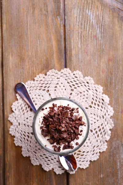 Iogurte, com creme de chocolate, chocolate picado e muesli servido em vidro sobre fundo de madeira — Fotografia de Stock