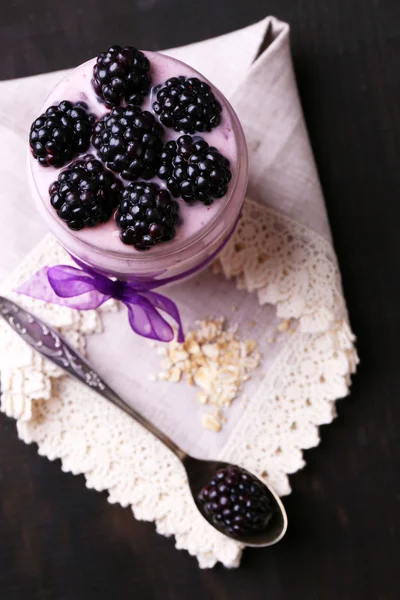 Zdrowe śniadanie - jogurt z musli i BlackBerry serwowane w szklanym słoiku, na ciemnym tle drewniane — Zdjęcie stockowe