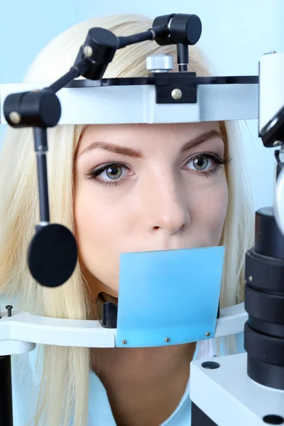 Optometrie concept - vrij jonge vrouw met haar ogen onderzocht door oogarts — Stockfoto