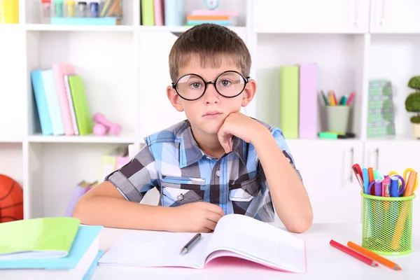 Schoolboy sitting at table in classroom — Stock Photo, Image