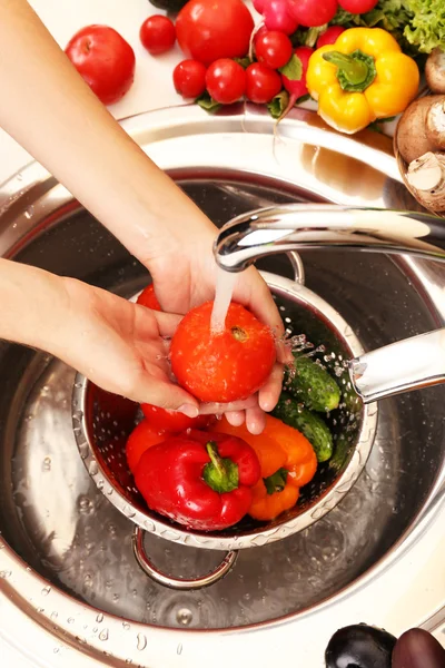 As mãos da mulher que lava verduras na pia na cozinha — Fotografia de Stock