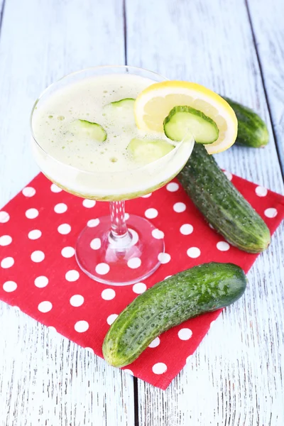 Cucumber cocktail with lemon on polka dot napkin on wooden background — Stock Photo, Image