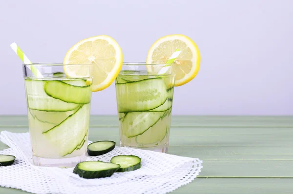 Two glasses of cucumber cocktail on napkin on wooden table on light background — Stock Photo, Image