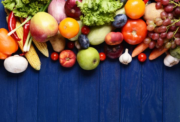 Frutas e legumes orgânicos frescos sobre fundo de madeira — Fotografia de Stock