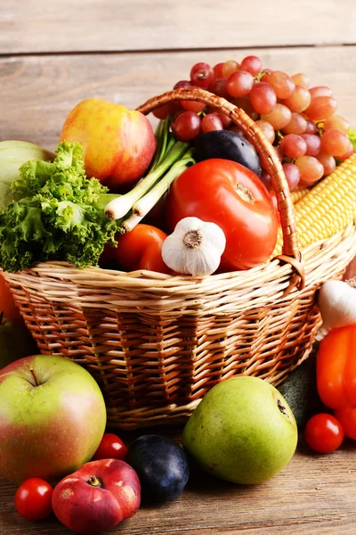 Verduras en canasta de mimbre sobre fondo de madera —  Fotos de Stock