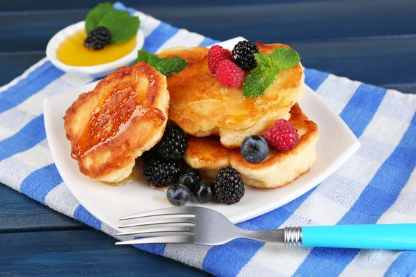 Tasty pancake with fresh berries and mint leaf on plate, on color wooden background — Stock Photo, Image