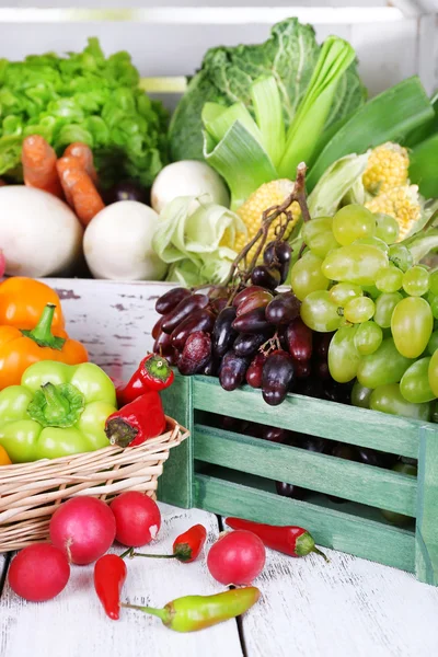 Vegetables in crate and in basket on white wooden box background — Stock Photo, Image