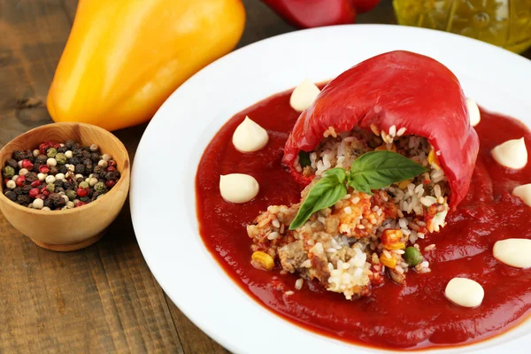 Bereid gevulde peper met tomatensaus op plaat, op houten achtergrond — Stockfoto