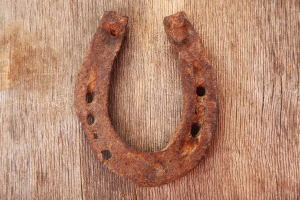 Sapato de cavalo velho no fundo de madeira — Fotografia de Stock