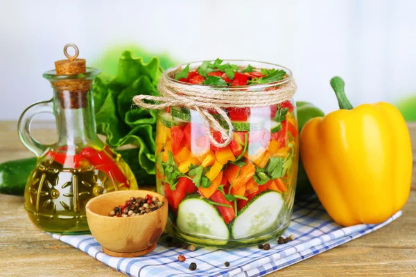 Salada de legumes em frascos de vidro na mesa de madeira, no fundo brilhante — Fotografia de Stock