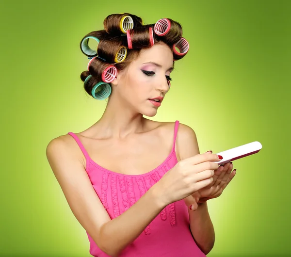 녹색 배경에 머리카락 curlers에서 아름 다운 소녀 — 스톡 사진