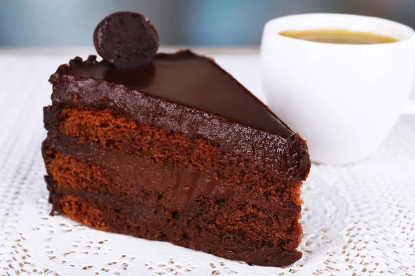 一块板和杯咖啡在餐巾纸上织物背景上的巧克力蛋糕 — 图库照片