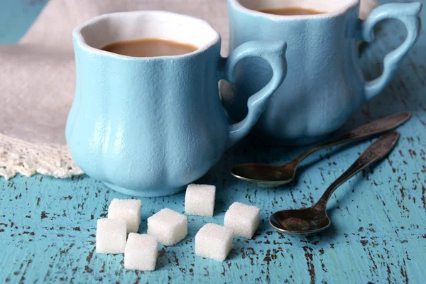 Cups of coffee with sugar and napkin on wooden table — Stock Photo, Image