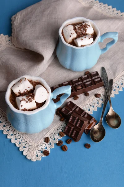 Tassen Kaffee mit Marshmallow und Schokolade auf Holztisch — Stockfoto