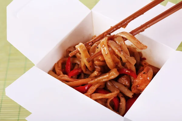 Fried noodles in takeaway box on mat background — Stock Photo, Image