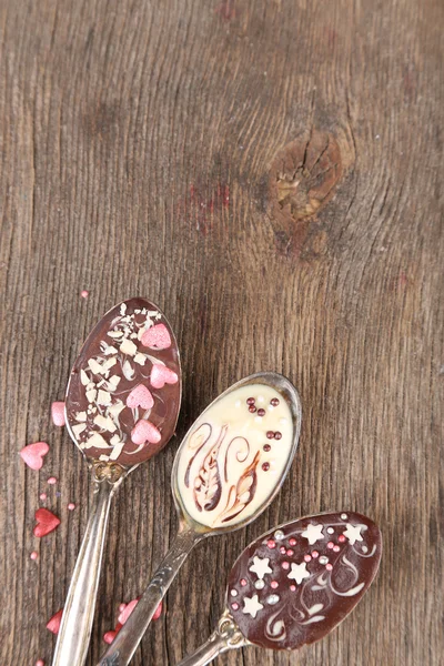Löffel mit leckerer Schokolade zum Feiern auf altem Holztisch — Stockfoto