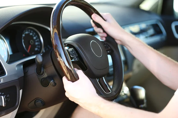 Man's hands on a steering wheel Royalty Free Stock Photos