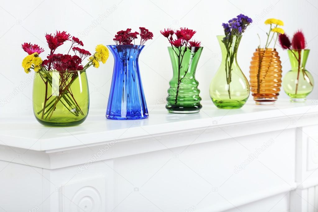 Colorful vases on white table, close-up