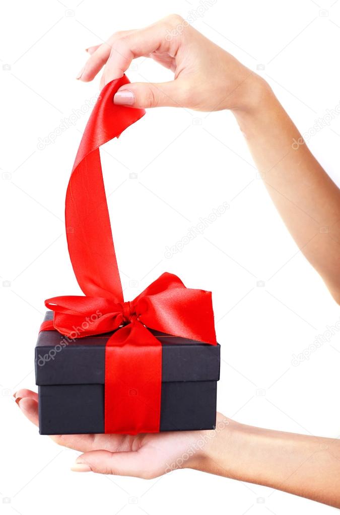 Woman's hand holding ribbon and opening gift box isolated on white