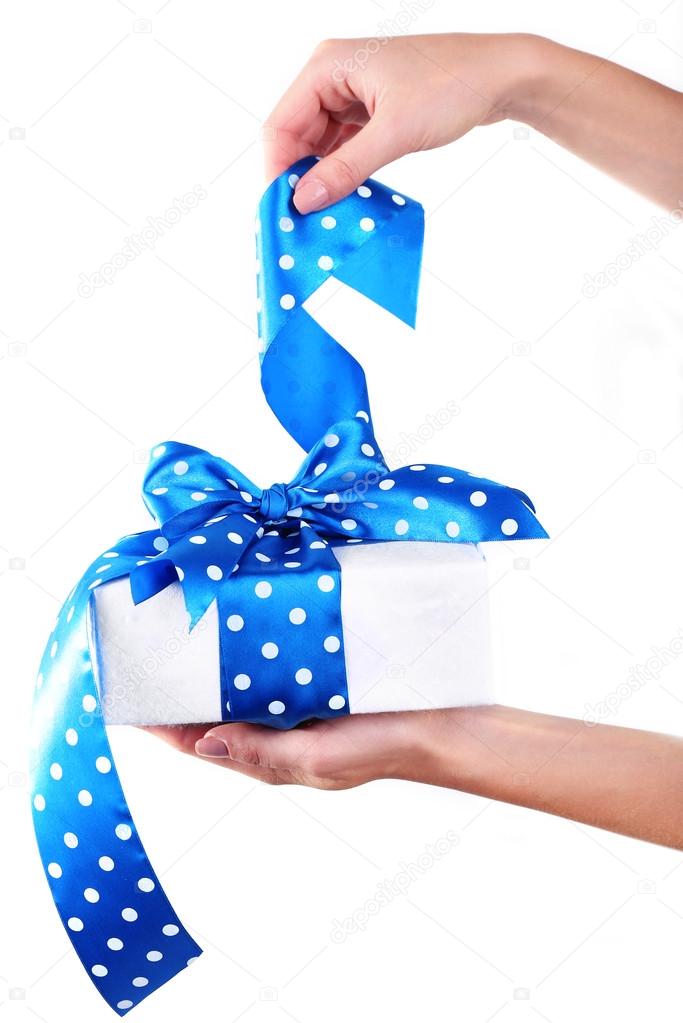 Woman's hand holding ribbon and opening gift box isolated on white