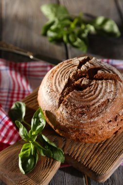 taze pişmiş ekmek ve ahşap zemin üzerinde kesme tahtası üzerinde taze fesleğen