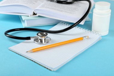 Not defteri ve kitaplar üzerinde mavi arka plan ile sağlık stetoskop