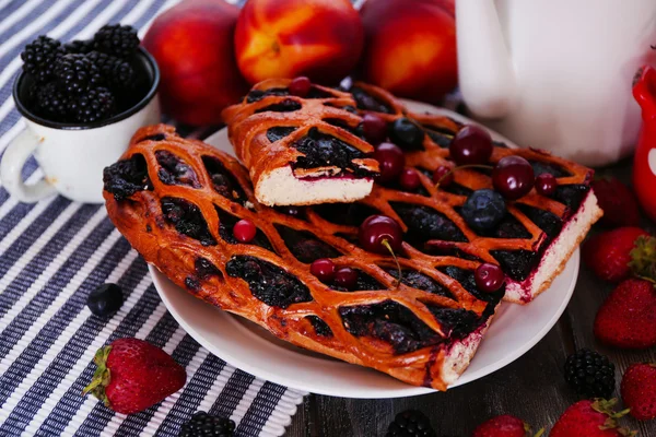 Sweet berry tart with berries on wooden table close-up