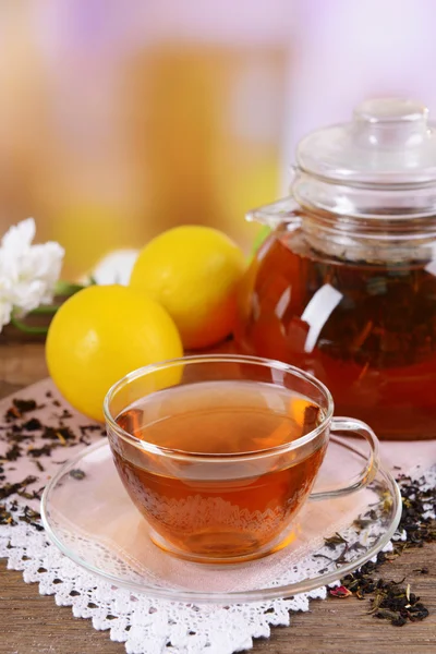 Teekanne und Tasse Tee auf Tisch auf hellem Hintergrund — Stockfoto