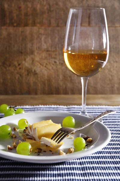 美丽的静物画与红酒，奶酪和成熟的葡萄，木制的背景上 — 图库照片