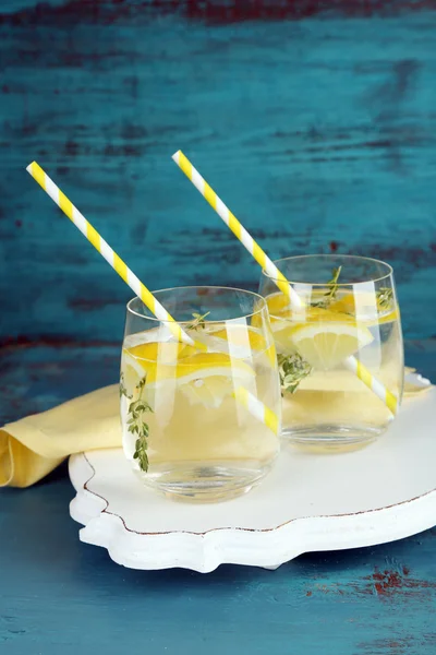 Вкусный прохладительный напиток с лимоном и тимьяном, на деревянном фоне — стоковое фото