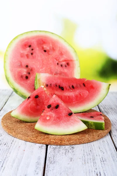 Watermeloen op snijplank op houten tafel op natuurlijke achtergrond — Stockfoto