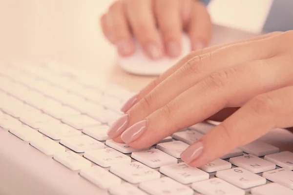 Mani femminili digitando sulla tastiera su sfondo chiaro — Foto Stock