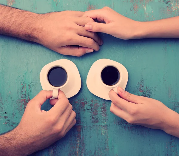 Tazas de café y de la mano en la mesa de madera — Foto de Stock