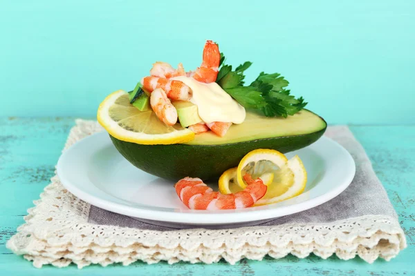 Salade savoureuse aux crevettes et avocat sur assiette, sur fond de bois — Photo