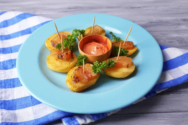 Baked potato with bacon on plate, on wooden background — Stock Photo, Image