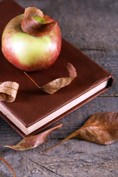 Pomme avec livre et feuilles sèches — Photo