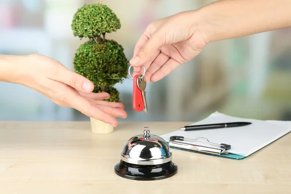 Female hand giving hotel key — Stock Photo, Image